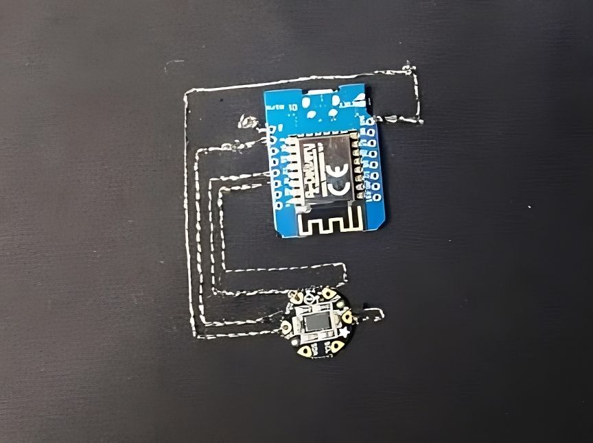 Wemos microcontroller and accelerometer embroidered onto the sleeve